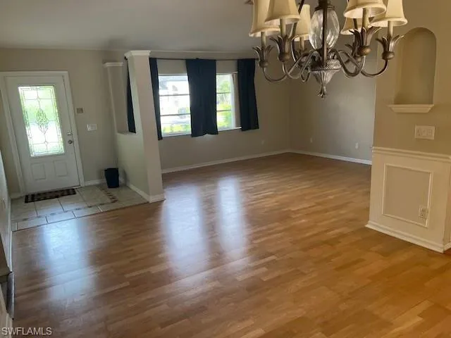 Entryway with hardwood / wood-style floors and an inviting chandelier