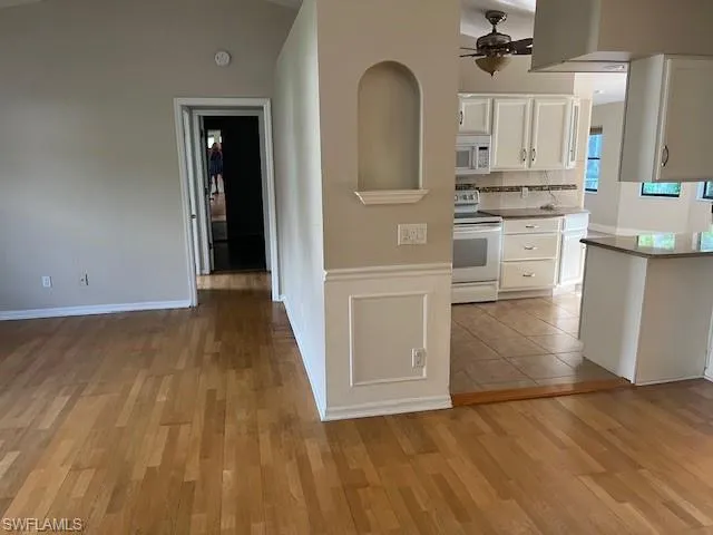 Kitchen featuring ceiling fan, light hardwood / wood-style flooring, white cabinetry, and white appliances