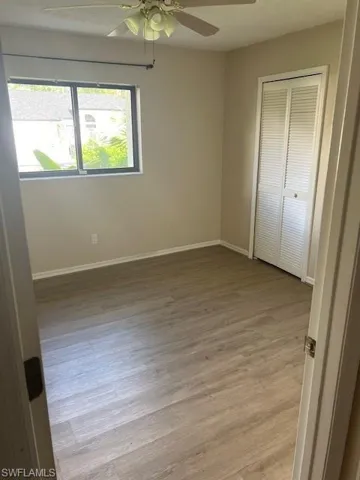 Spare room featuring ceiling fan, a wealth of natural light, and light hardwood / wood-style flooring