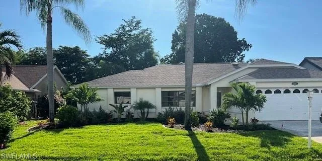 Ranch-style home with a garage and a front lawn