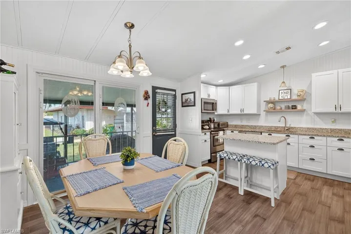 Dining room featuring a chandelier, dark wood-type flooring, recessed lighting, vaulted ceiling, and wooden walls