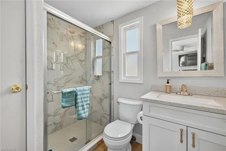 Full bathroom with vanity and a marble finish shower