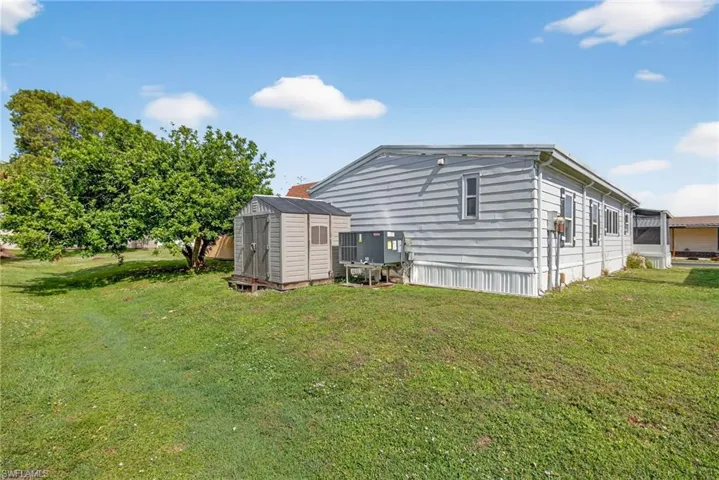 Back of property featuring a shed and a lawn