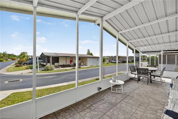 Sunroom featuring vaulted ceiling and a residential view