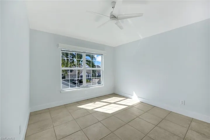 Tiled spare room with ceiling fan