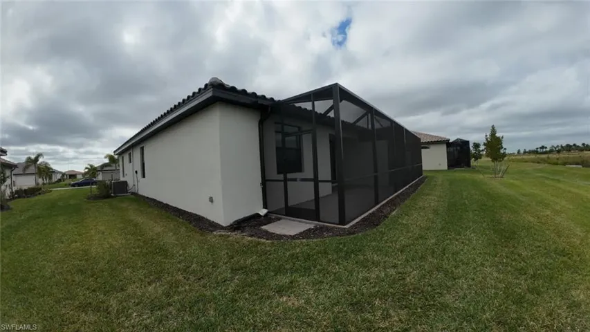 View of property exterior with a lawn, a sunroom, stucco siding, and a lanai