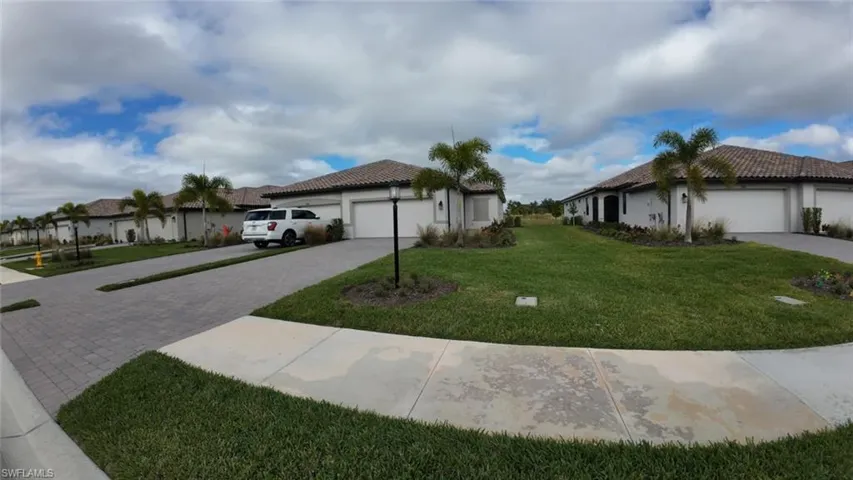 View of home's exterior featuring a yard, driveway, stucco siding, and a garage