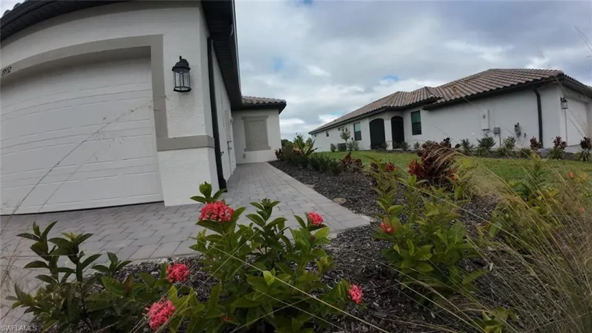 View of side of property featuring stucco siding and a tiled roof