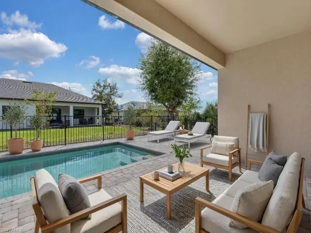 View of pool with patio surround, outdoor lounge area, and a lawn