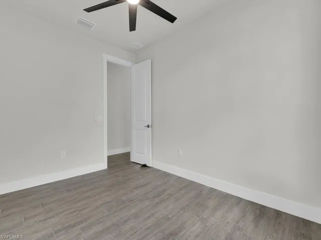 Unfurnished room with wood finished floors and ceiling fan