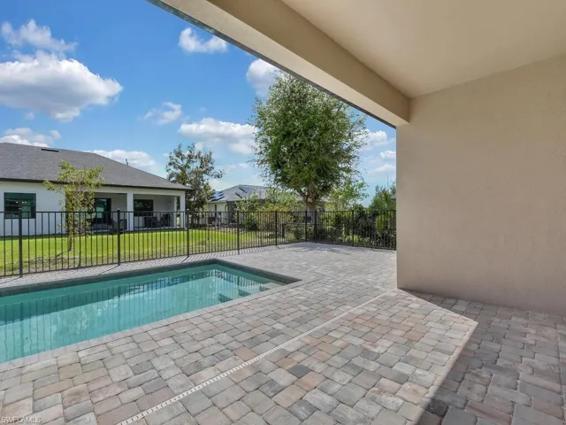 View of swimming pool featuring patio surround and a fenced backyard