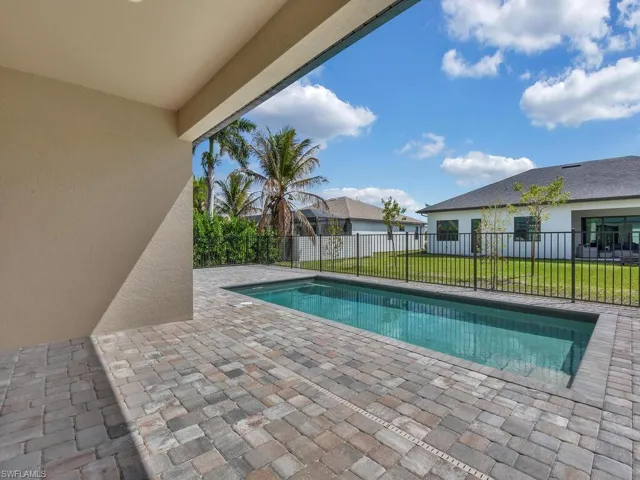 View of swimming pool featuring patio surround and a fenced backyard
