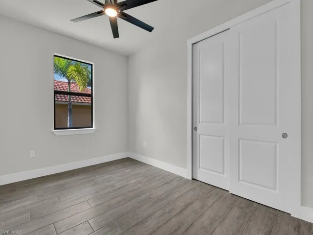 Unfurnished bedroom featuring light wood-style floors, ceiling fan, and a closet