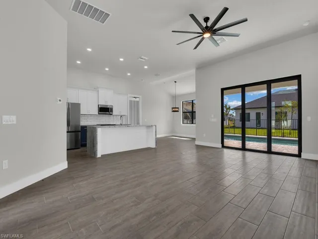 Unfurnished living room with a ceiling fan, wood tiled floors, and recessed lighting