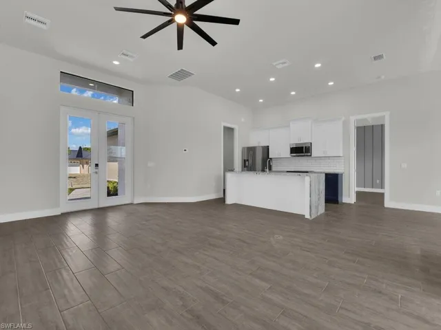 Unfurnished living room featuring ceiling fan, french doors, wood finish floors, and recessed lighting