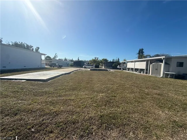 View of grassy yard featuring a shed