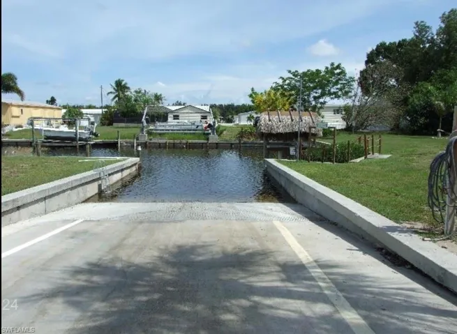 Dock area featuring a yard, a boat ramp, and a water view
