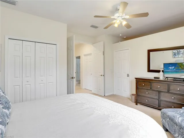 Secondary bedroom featuring ceiling fan & owners locked closet.