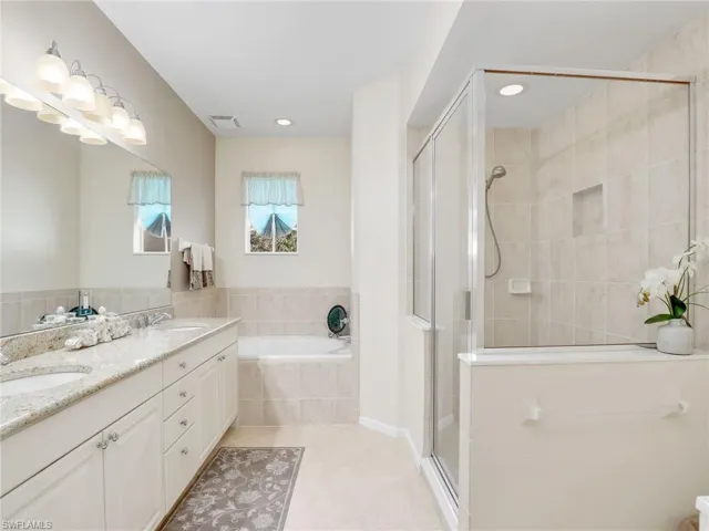 Primary Bathroom with dual sink vanity, independent shower and bath, and tile patterned flooring