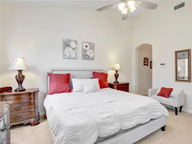 Primary bedroom with high vaulted ceiling and ceiling fan