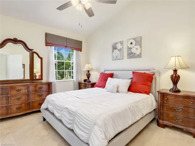 Primary bedroom with ceiling fan and vaulted ceiling.