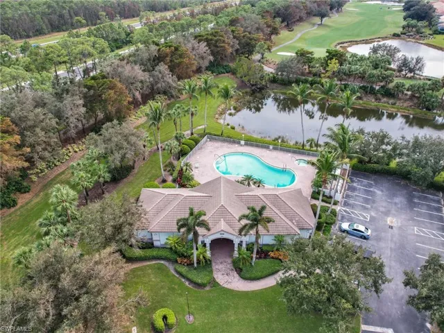 Aerial view of club house and pool with a water view.