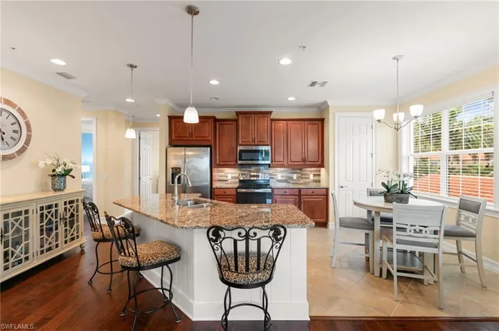 Large Open Kitchen with granite surfaces, NEW stainless appliances, tile backsplash & under cabinet lighting!