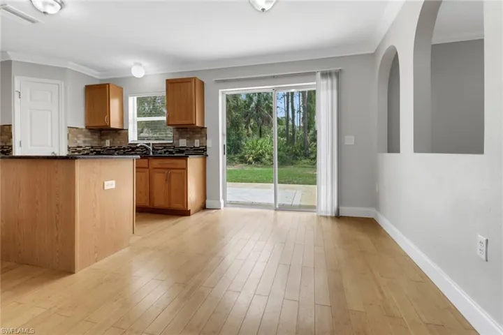 Kitchen with light hardwood / wood-style floors, tasteful backsplash, and plenty of natural light