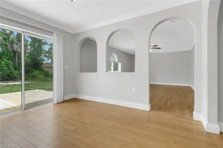 Unfurnished room with ceiling fan, light wood-type flooring, and ornamental molding