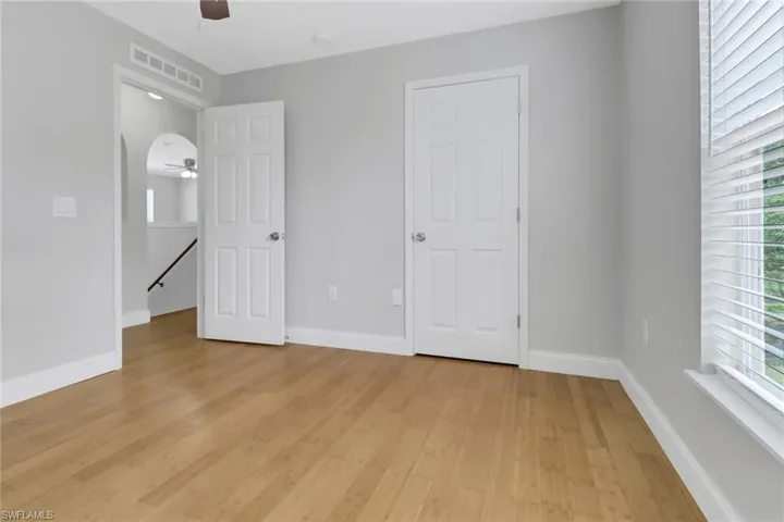 Unfurnished bedroom with light hardwood / wood-style flooring and multiple windows