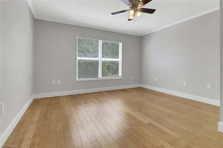 Unfurnished room with light hardwood / wood-style floors, ornamental molding, and ceiling fan