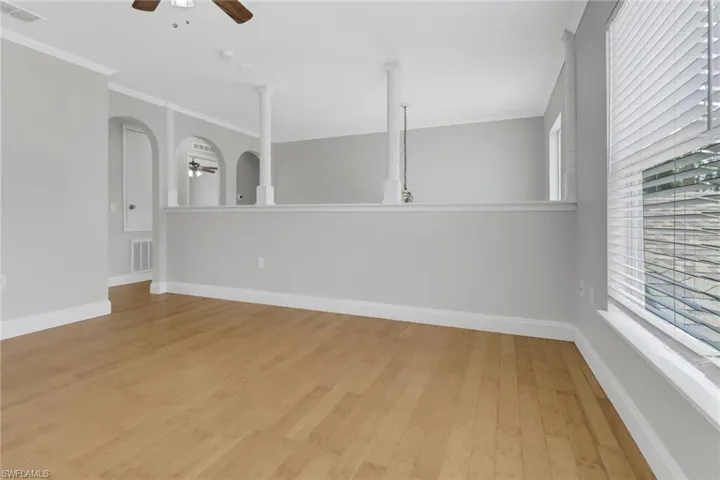 Spare room with a healthy amount of sunlight, ceiling fan, and light hardwood / wood-style flooring