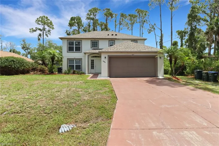 View of front of house with a garage and a front lawn