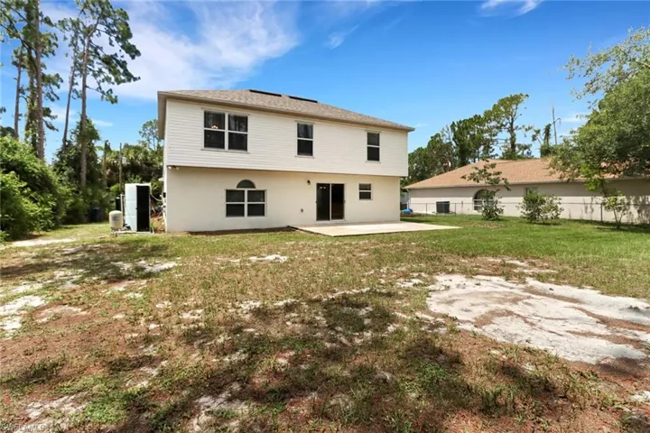 Back of property featuring a patio and a yard