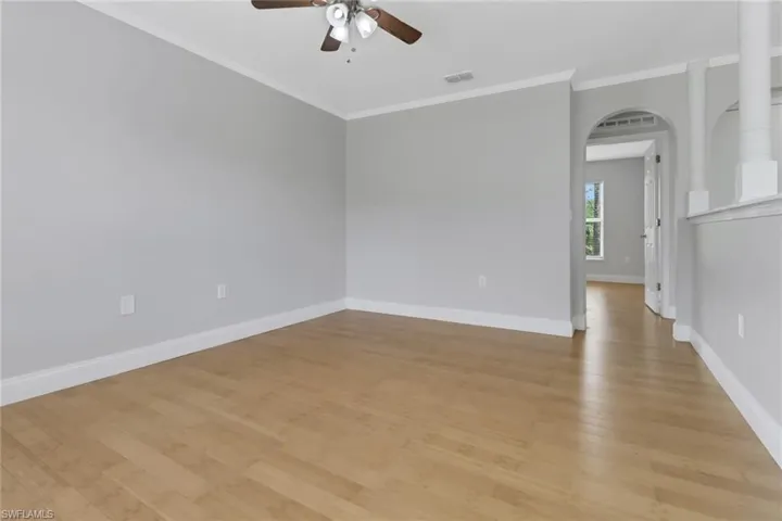 Spare room with ornamental molding, ceiling fan, and light hardwood / wood-style flooring