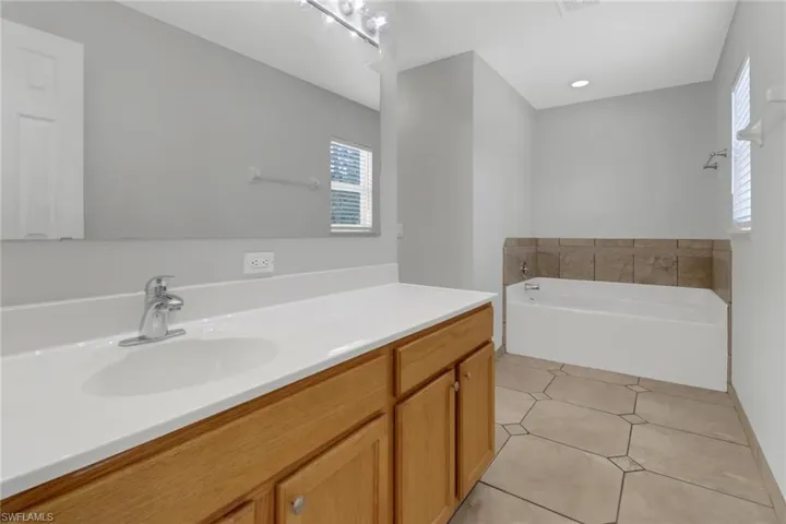 Bathroom with a bath to relax in, tile flooring, and large vanity