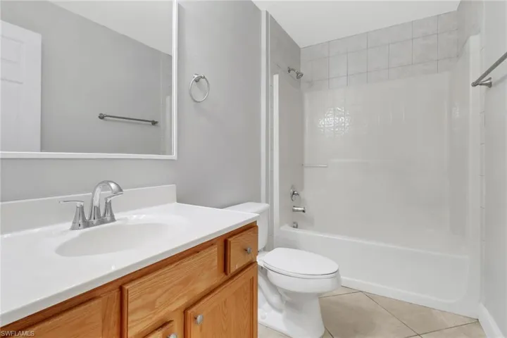 Full bathroom featuring tile floors, shower / tub combination, toilet, and vanity