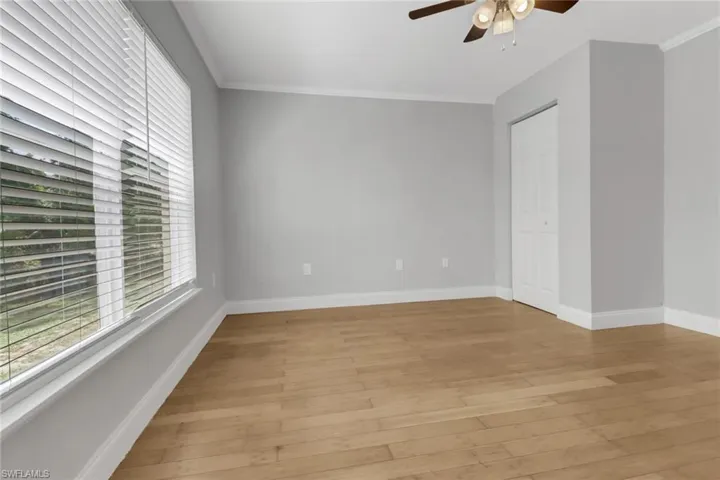 Empty room featuring ceiling fan, ornamental molding, and light hardwood / wood-style floors