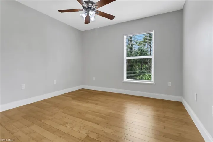 Empty room with ceiling fan and light hardwood / wood-style floors