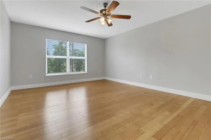 Unfurnished room with ceiling fan and light hardwood / wood-style floors