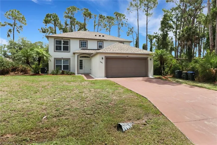View of front of house featuring a garage, a front yard, and central AC unit
