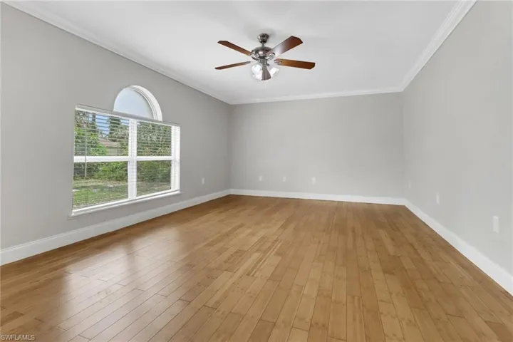 Unfurnished room featuring ceiling fan, light hardwood / wood-style floors, and crown molding