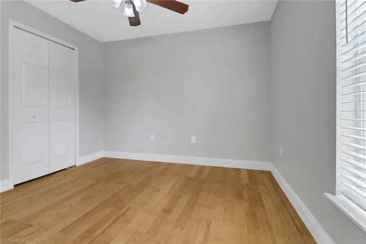 Unfurnished bedroom with ceiling fan, a closet, and light wood-type flooring