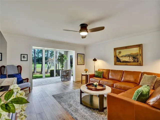 Living area with crown molding, hardwood / wood-style floors, and a ceiling fan