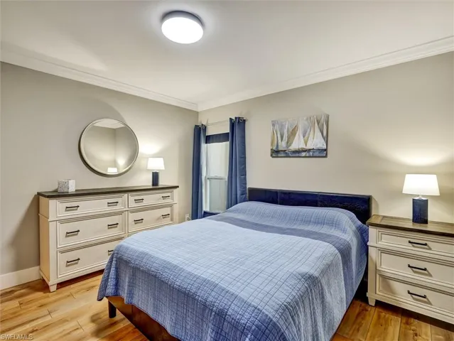 Bedroom with crown molding and light wood finished floors