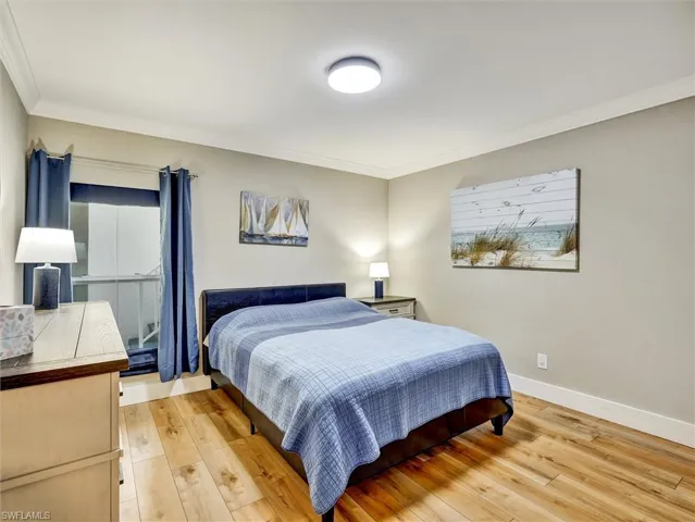Bedroom with light wood-style floors and ornamental molding