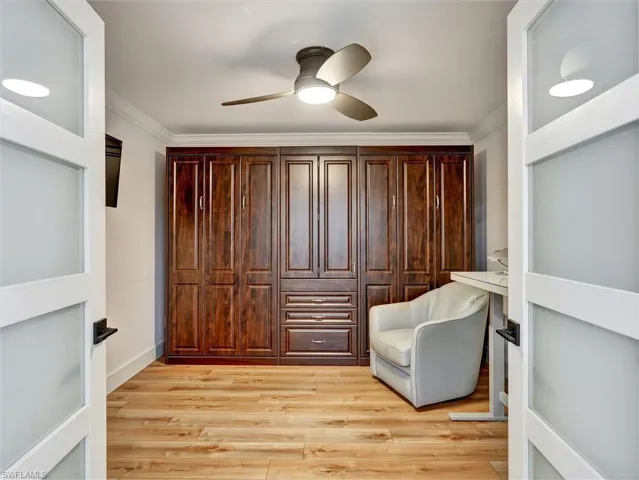 Sitting room with light wood-style flooring, ornamental molding, and a ceiling fan