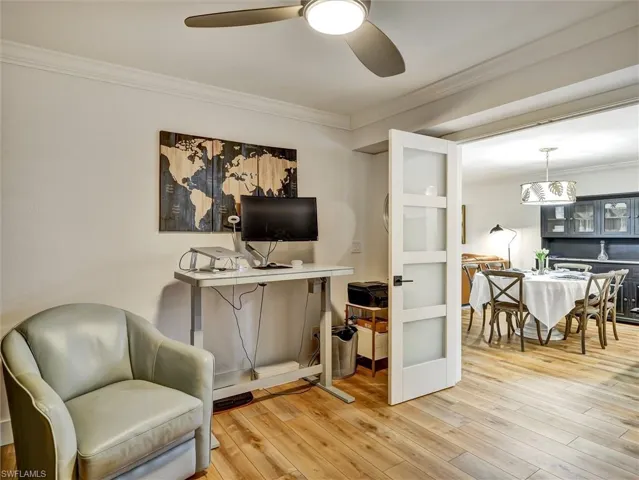 Living area featuring ornamental molding, light wood finished floors, ceiling fan, and a desk