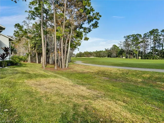 View of green lawn with view of scattered trees and golf course view
