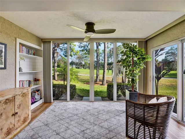 Sunroom / solarium with ceiling fan and view of golf course